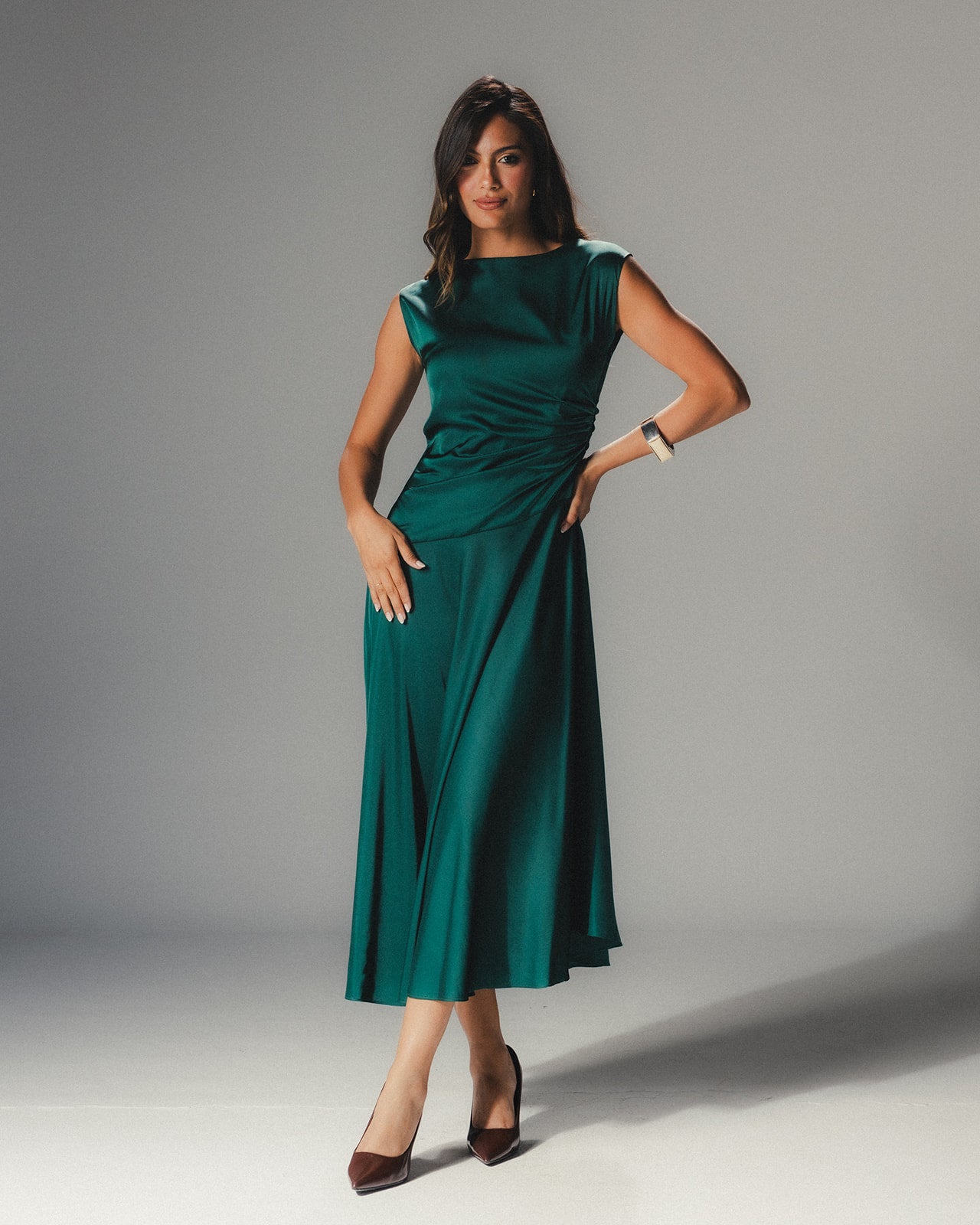 Full-length view of the emerald Satin Armani dress demonstrating its liquid-like movement and mid-length hem