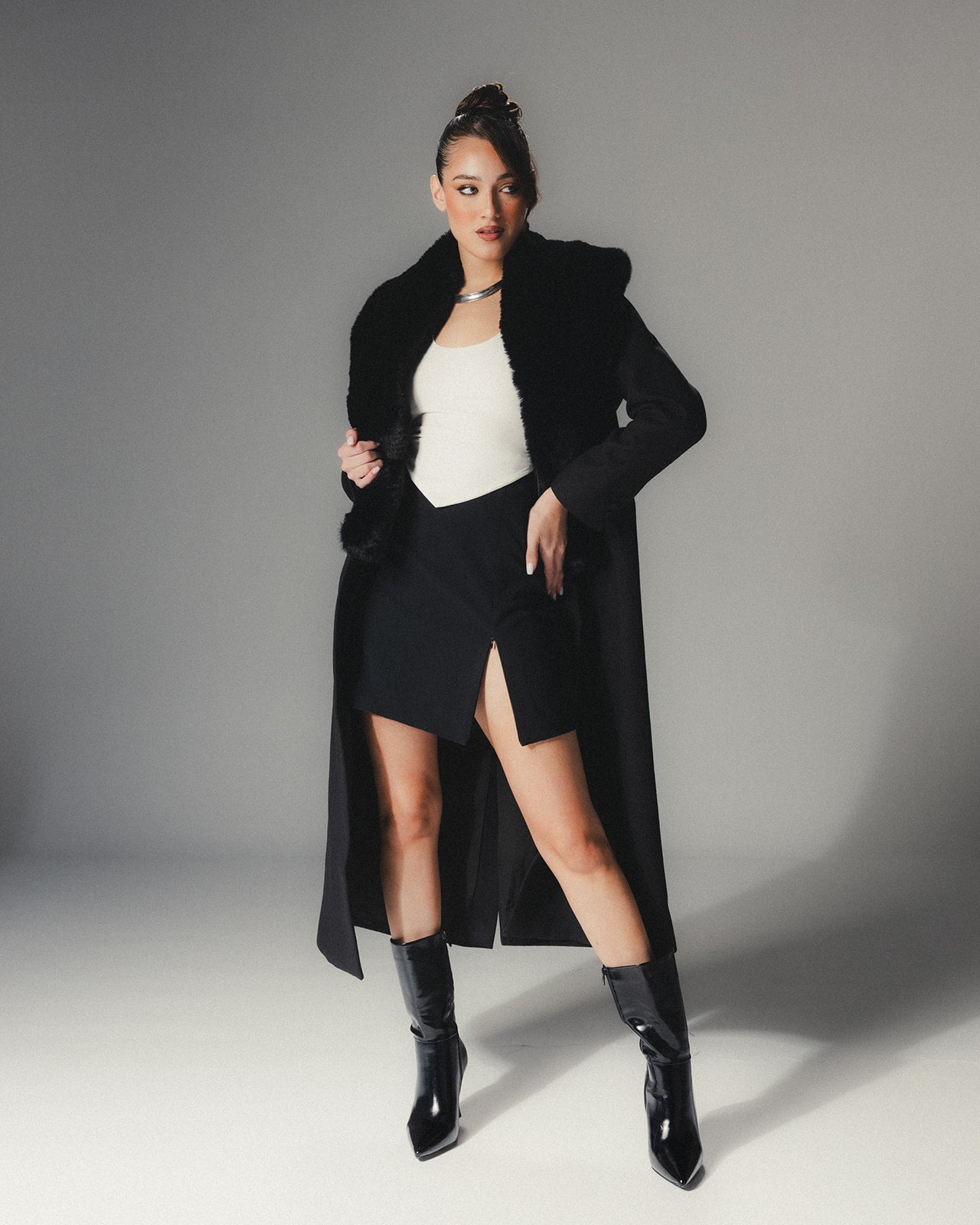 Front view of MYSHA Obsidian black premier wool coat with plush detachable fur collar on a high-fashion model.