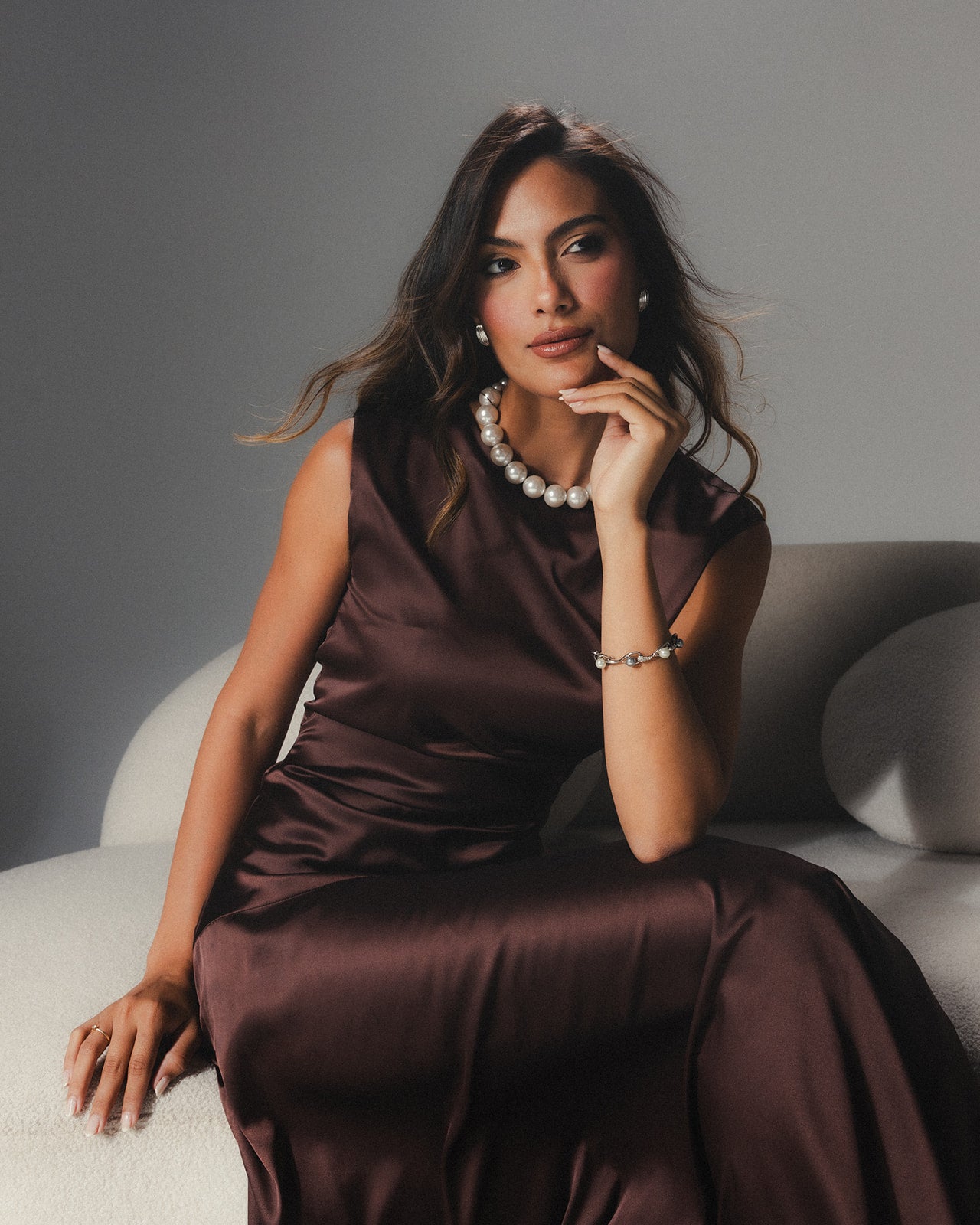 Close-up of the modern asymmetrical hemline on the MYSHA Espresso brown satin dress.