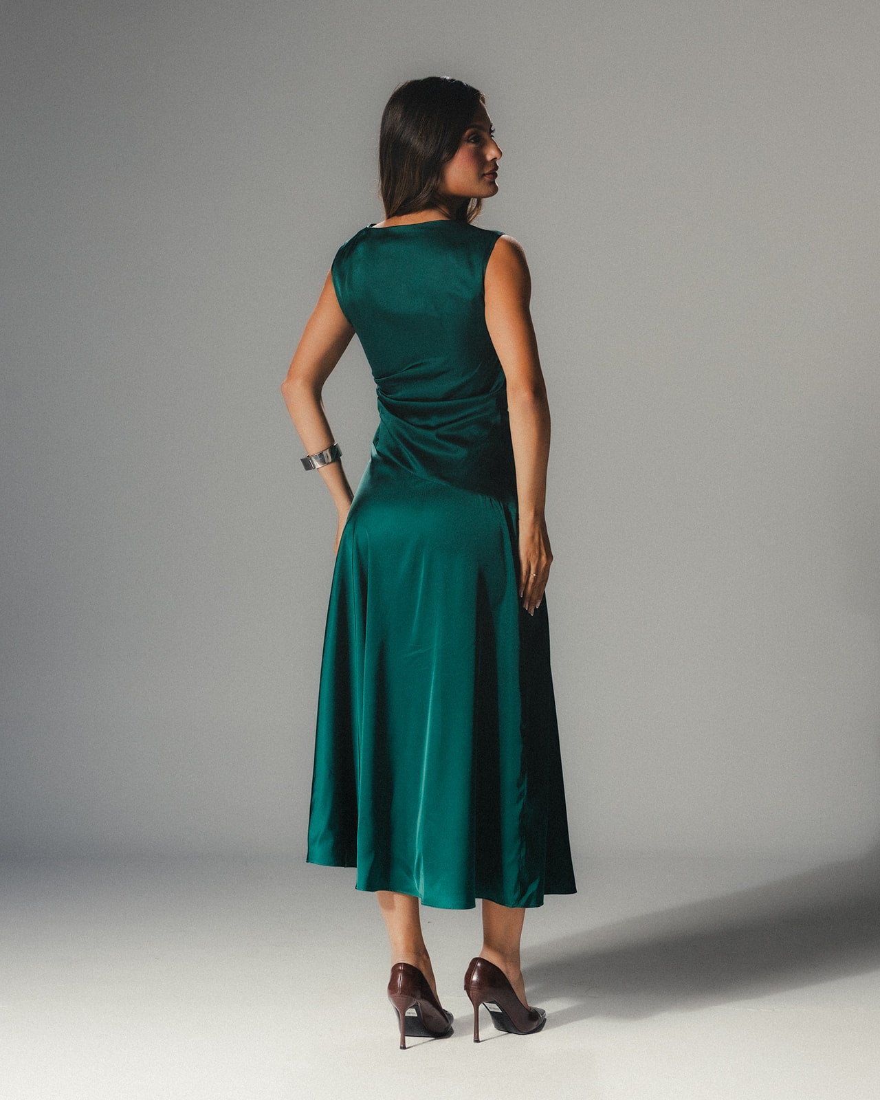 Back view: Full-length view of the emerald Satin Armani dress demonstrating its liquid-like movement and mid-length hem