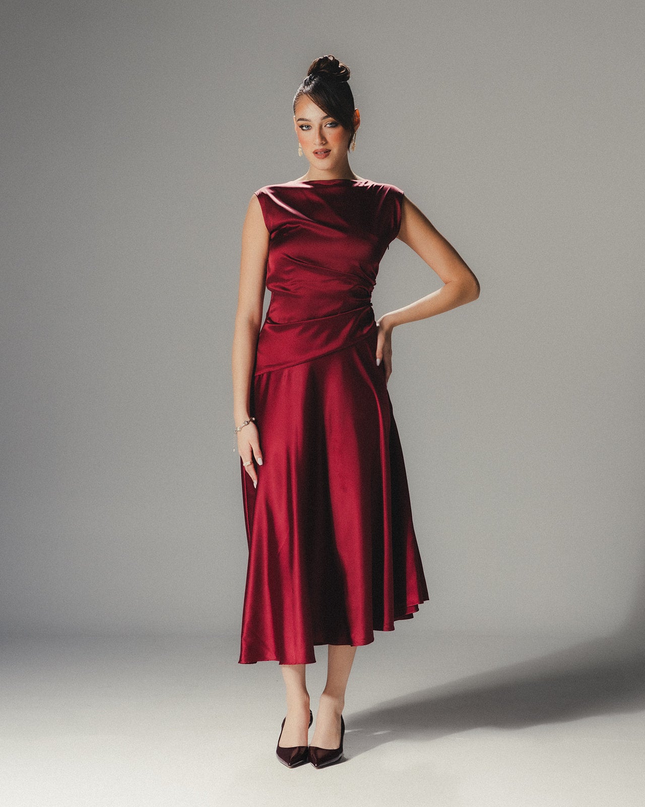 Model in the MYSHA ruby red Satin Armani midi dress demonstrating the fluid movement of the asymmetrical hem